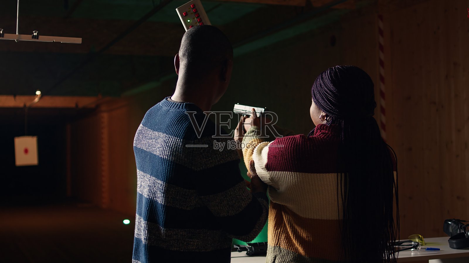 射击场专家为女性提供手持手枪的指导照片摄影图片