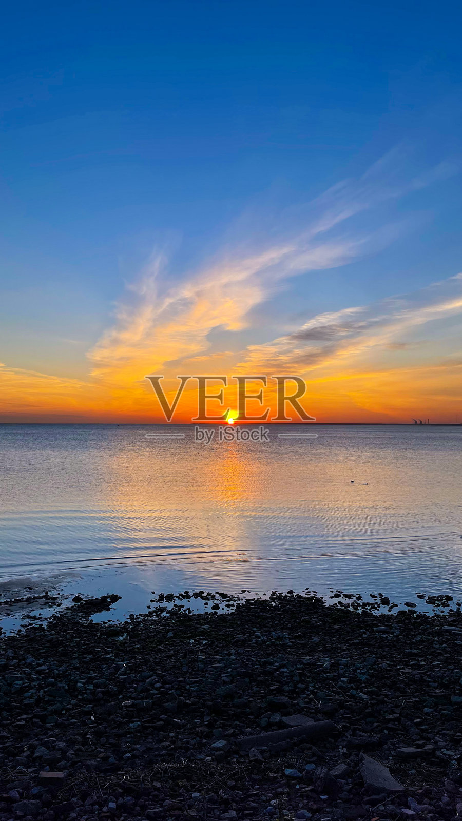 明亮的日落,黄色的太阳在水面下。宁静的海上日落。夏季傍晚。竖版摄影。照片摄影图片