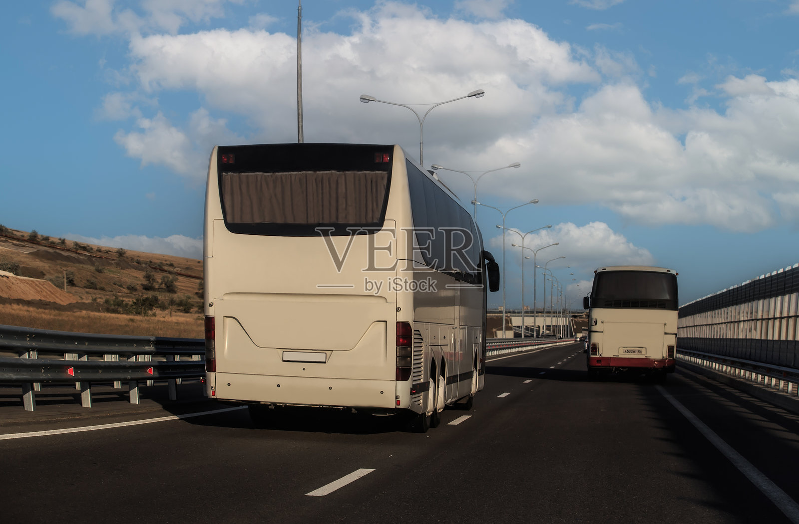 旅游巴士沿着道路行驶照片摄影图片