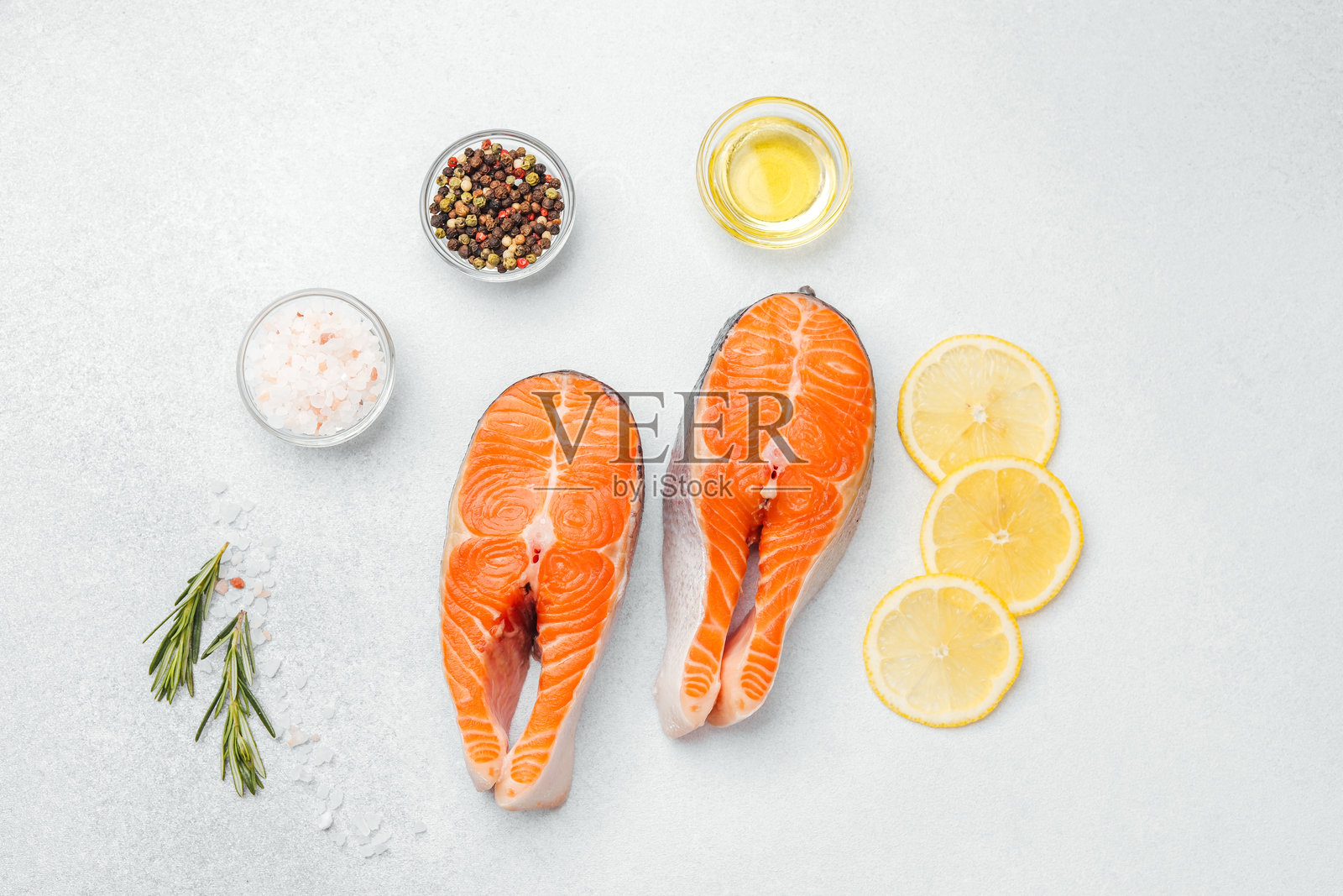 新鲜的三文鱼片配调料和柠檬,准备烹饪。照片摄影图片