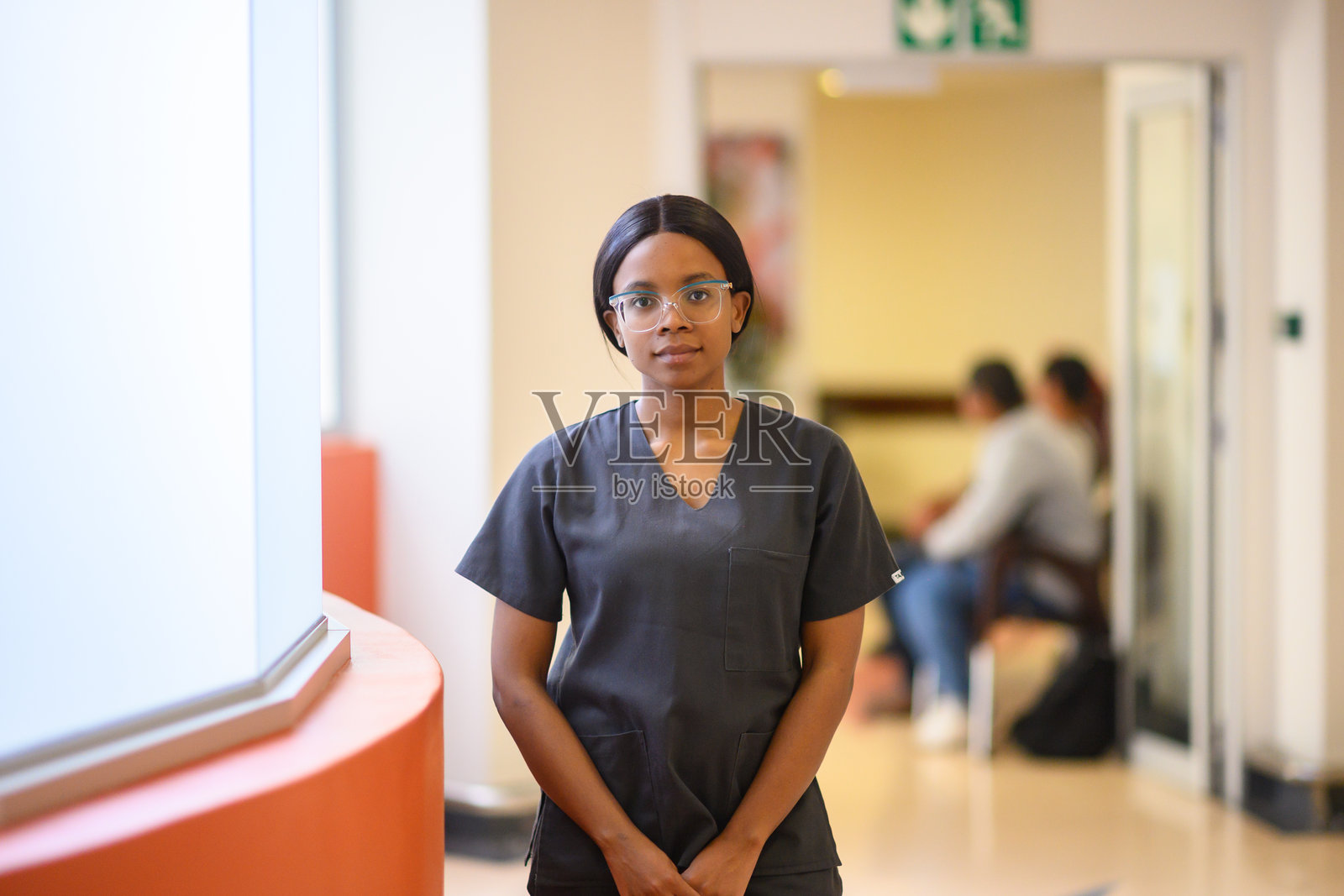 自信的年轻医疗专业人员穿着手术服站在医院走廊里照片摄影图片