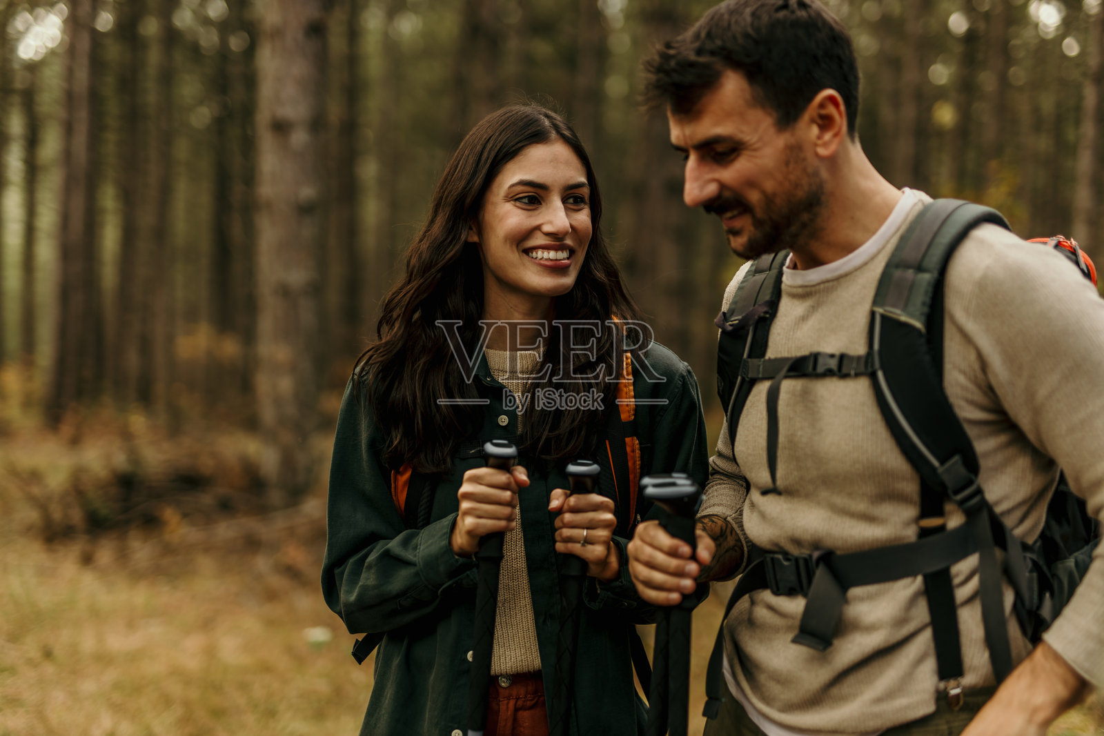 秋季时,徒步旅行者在森林中行走并交谈照片摄影图片