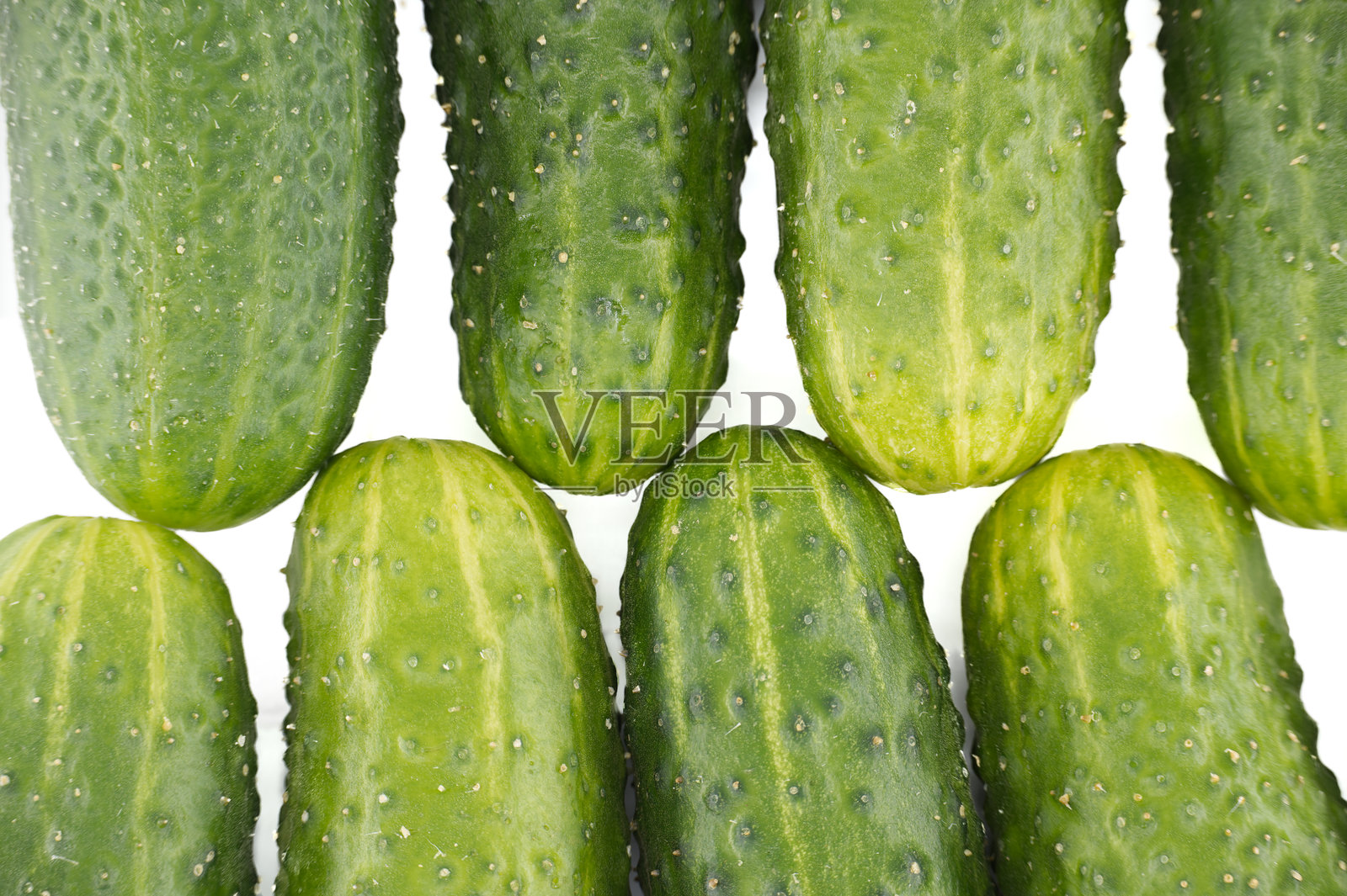 特写展示了新鲜的绿色黄瓜,背景为清脆的白色。照片摄影图片