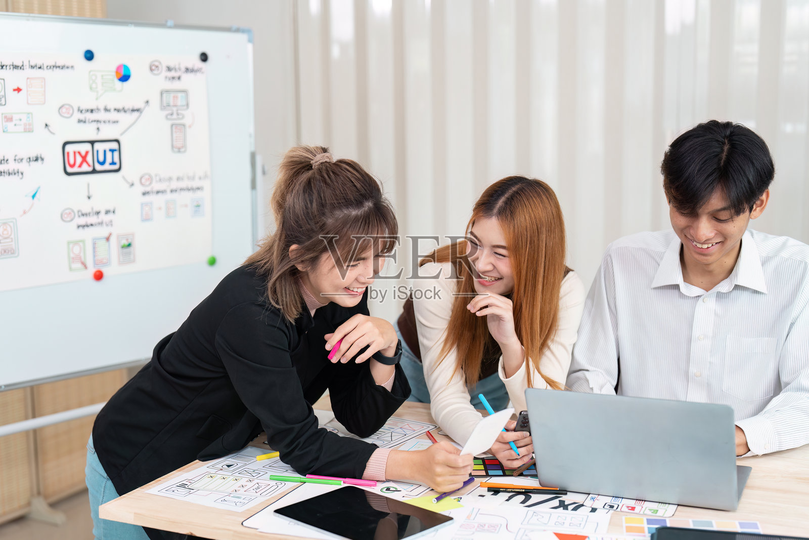 参与设计团队与创意构思。三位设计师在一次充满活力的用户体验与用户界面项目会议中分享欢笑并进行头脑风暴。照片摄影图片