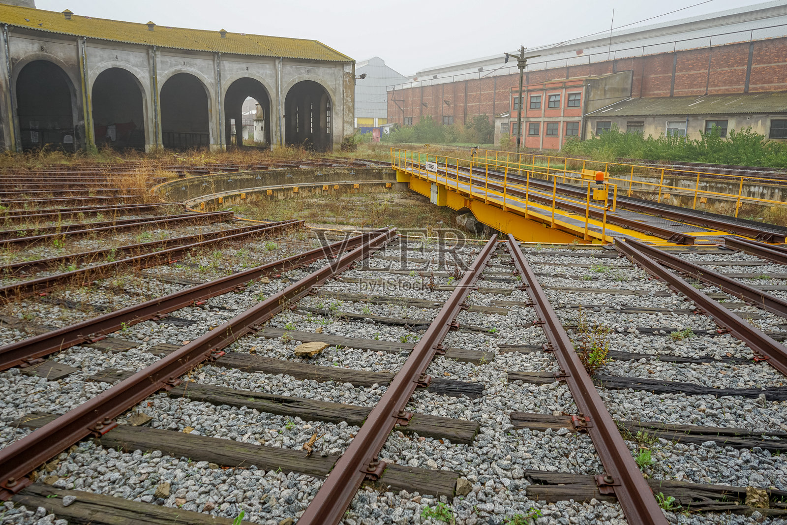 火车轨道,背景是旧火车车间。照片摄影图片
