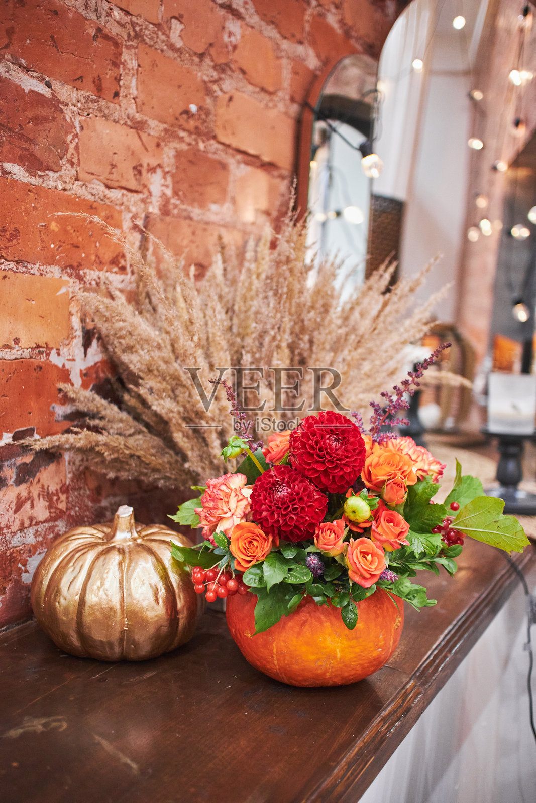 南瓜花瓶中的秋季花束。美丽的感恩节和万圣节花卉装饰。温馨的家居氛围,秋季装饰。照片摄影图片