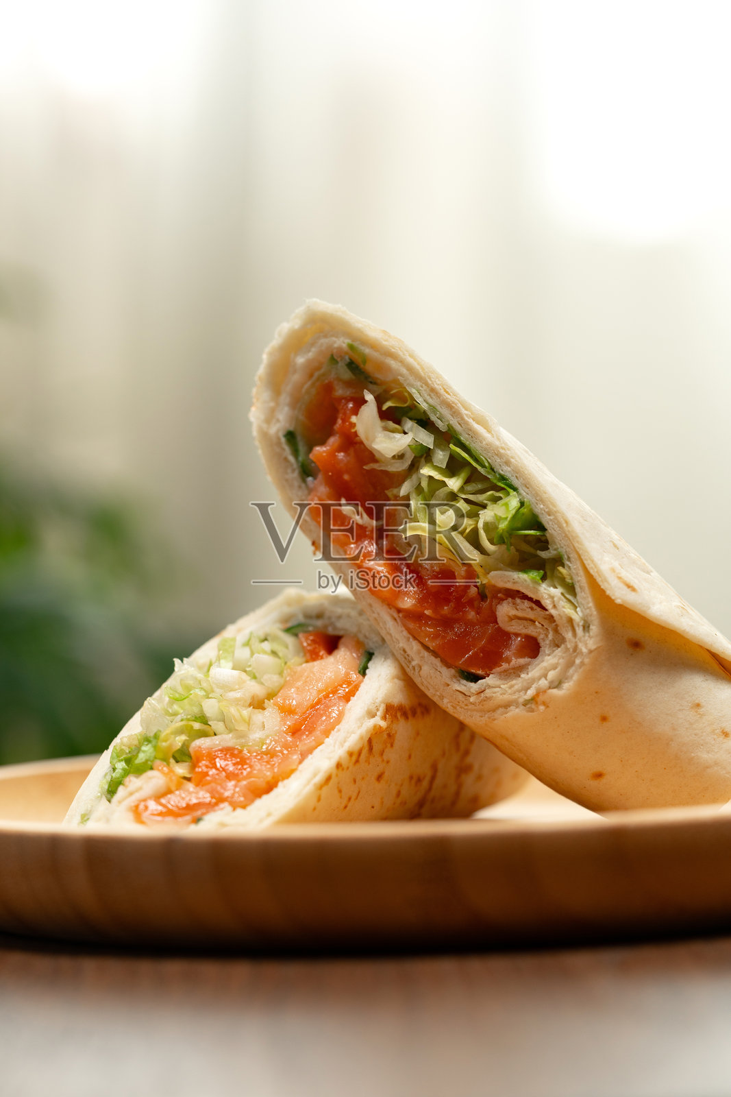 新鲜准备的蔬菜酱卷饼放在明亮厨房环境中的木盘上照片摄影图片