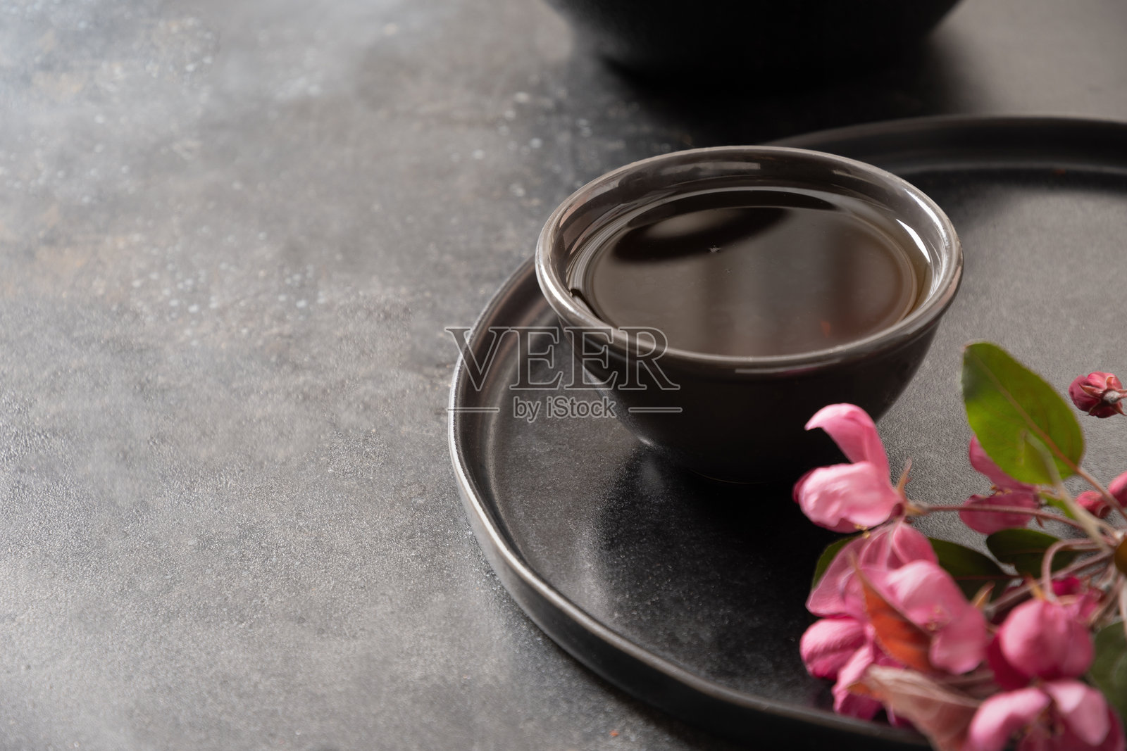 黑色中国茶具与盛开的粉色苹果花。照片摄影图片