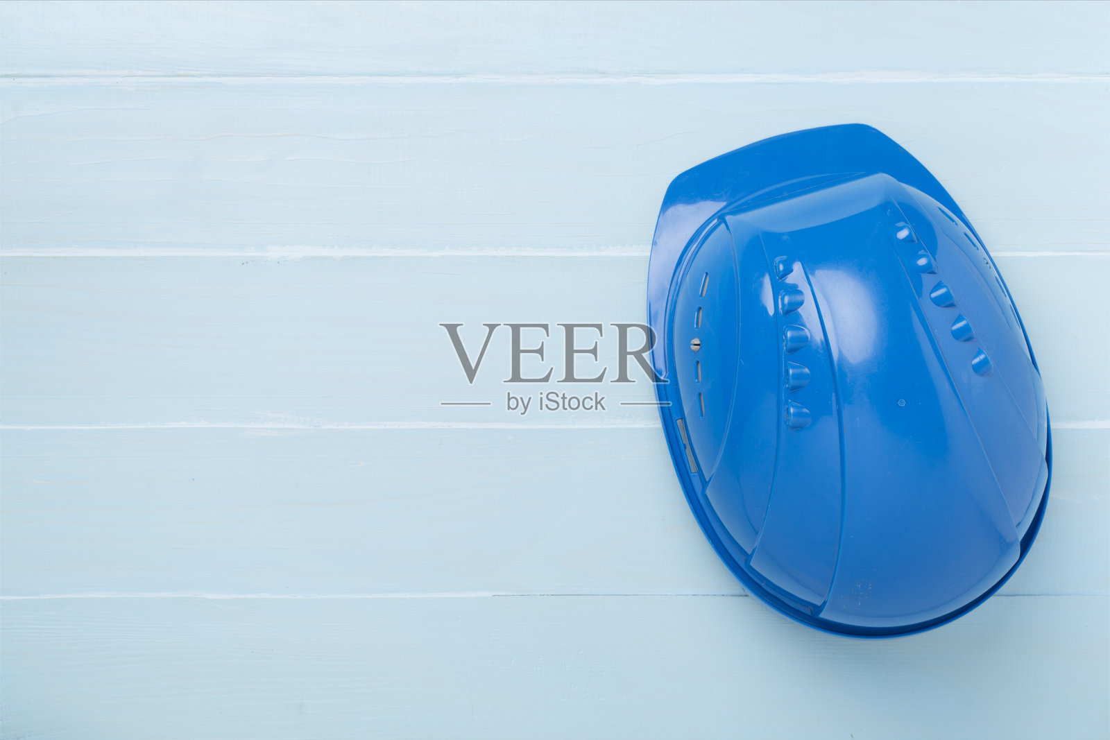 蓝色建筑安全帽放在木质背景上,俯视图照片摄影图片