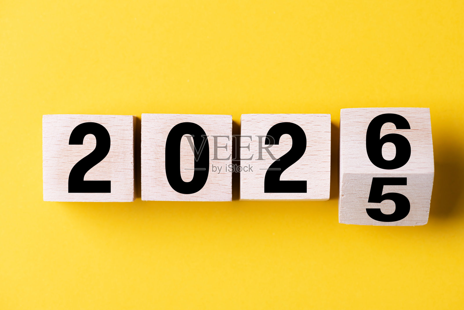 2026年快乐新年。木制立方体从2025变为2026,背景为蓝色。2026新年概念背景。商业、决心、目标、灵感、成功、创意。照片摄影图片