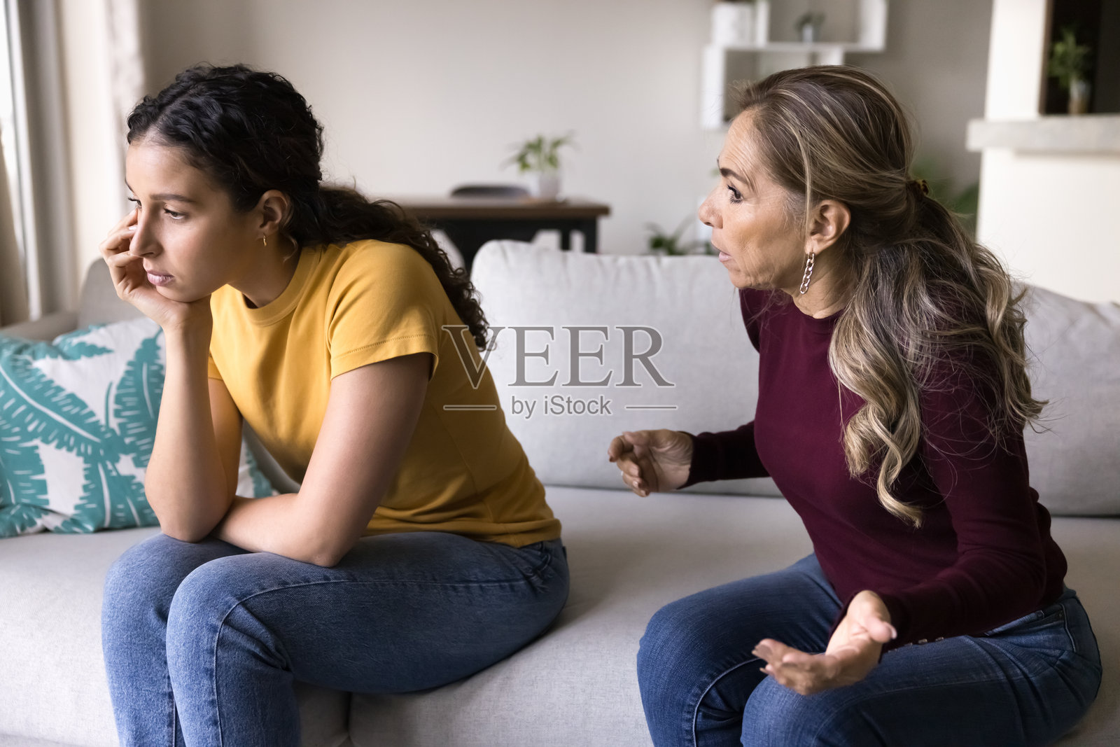 烦恼的拉丁裔母亲与倔强的女儿争吵照片摄影图片