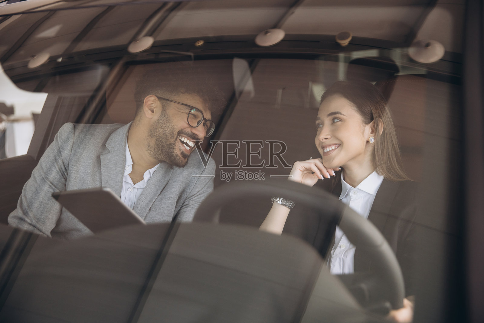 汽车销售员在汽车经销商处向女性顾客展示新车照片摄影图片