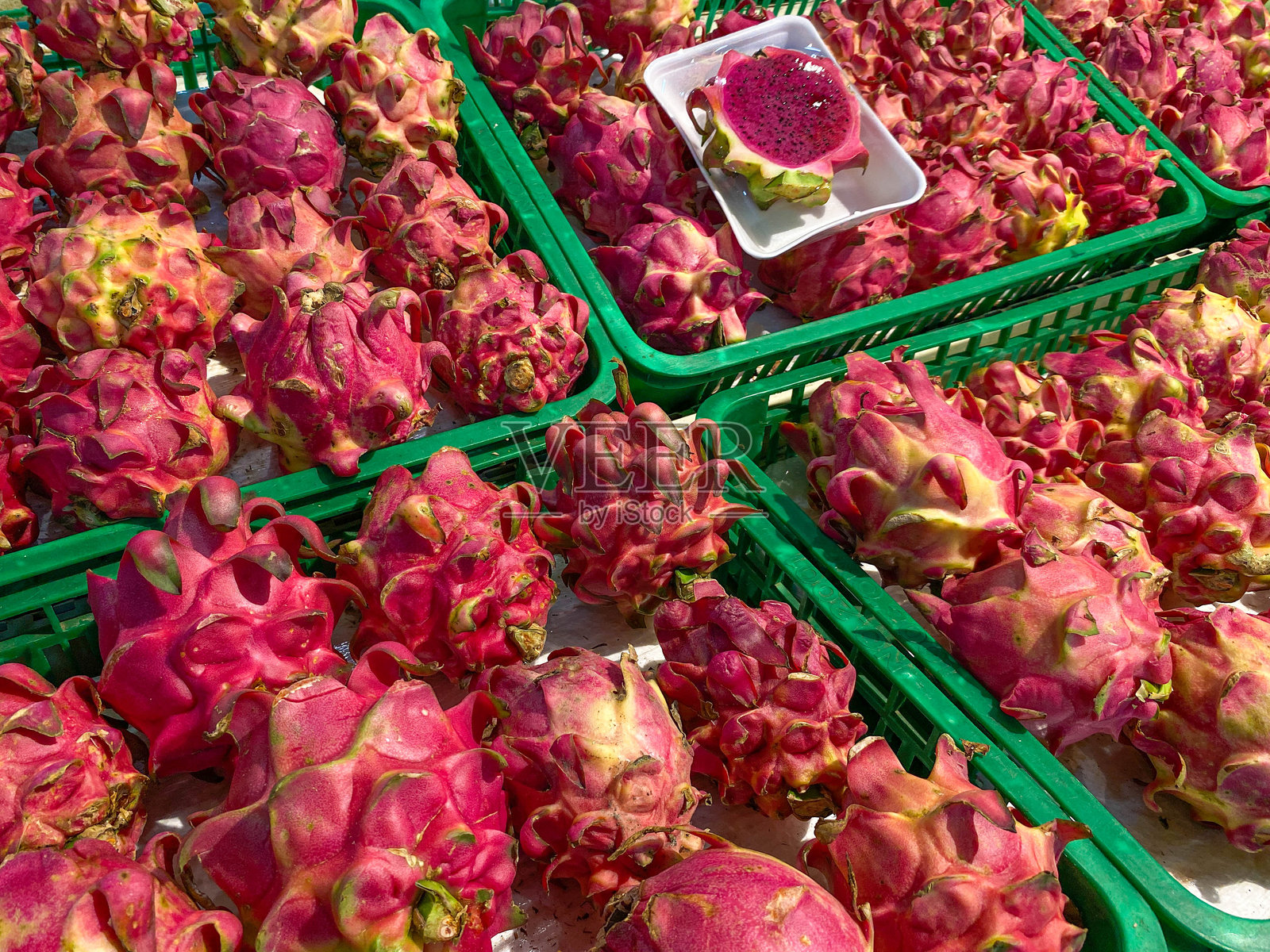 红心火龙果,放在超市摊位的绿色盒子上照片摄影图片