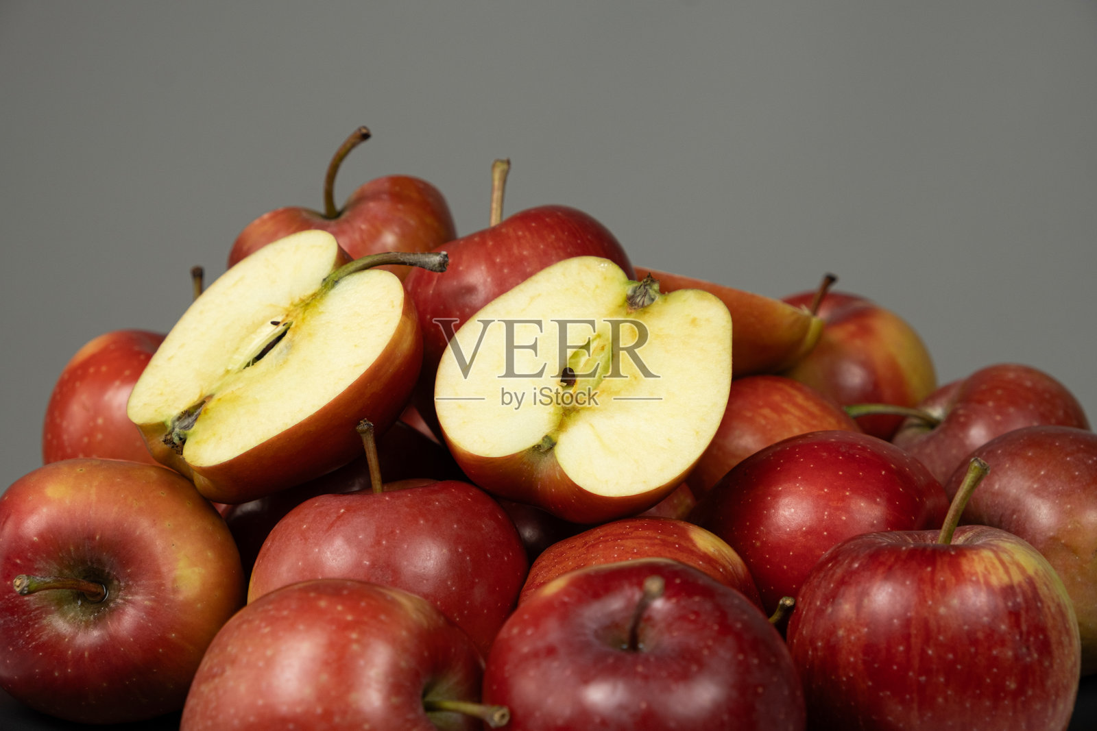 一组新鲜的红色整苹果和苹果半切的特写。照片摄影图片