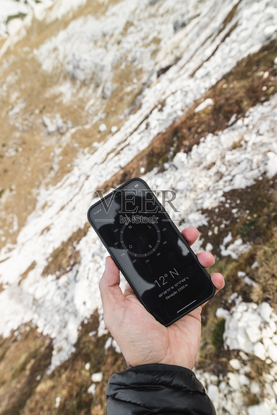 手握智能手机指南针应用程序在多洛米蒂山脉照片摄影图片