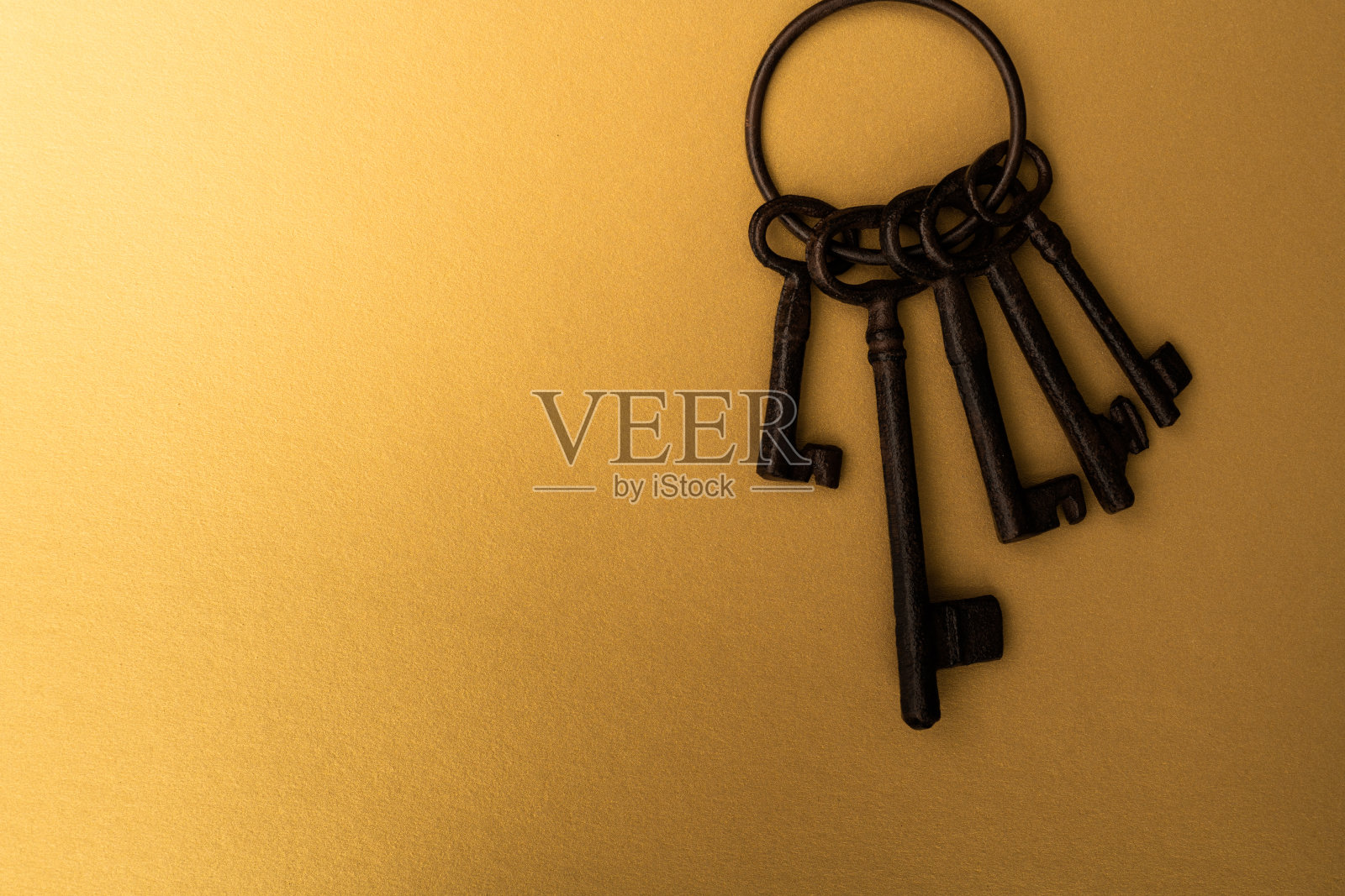 一串旧钥匙在黄色背景上照片摄影图片