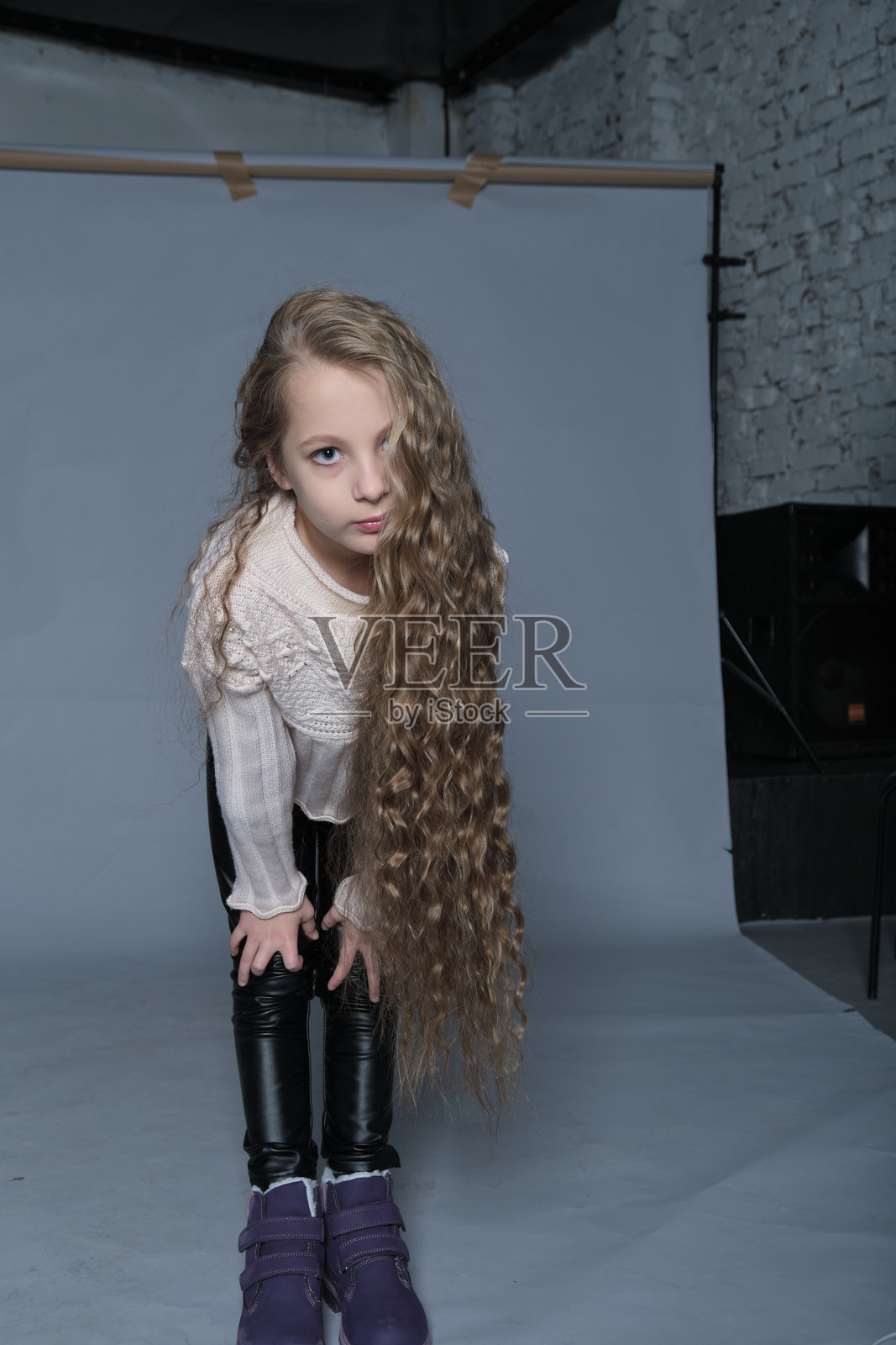 一个长着丰盈卷发的女孩享受着无忧无虑的时刻,展示她健康而闪亮的秀发。这个场景强调了儿童护发的重要性,突显使用合适的产品进行梳理和滋润的好处。照片摄影图片