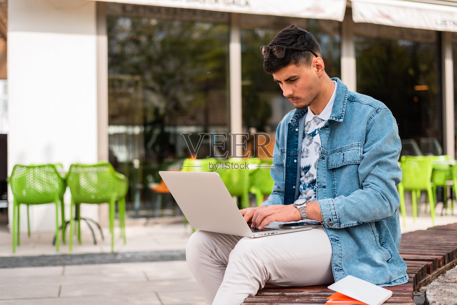 一名男大学生或年轻自由职业者在咖啡馆使用笔记本电脑照片摄影图片