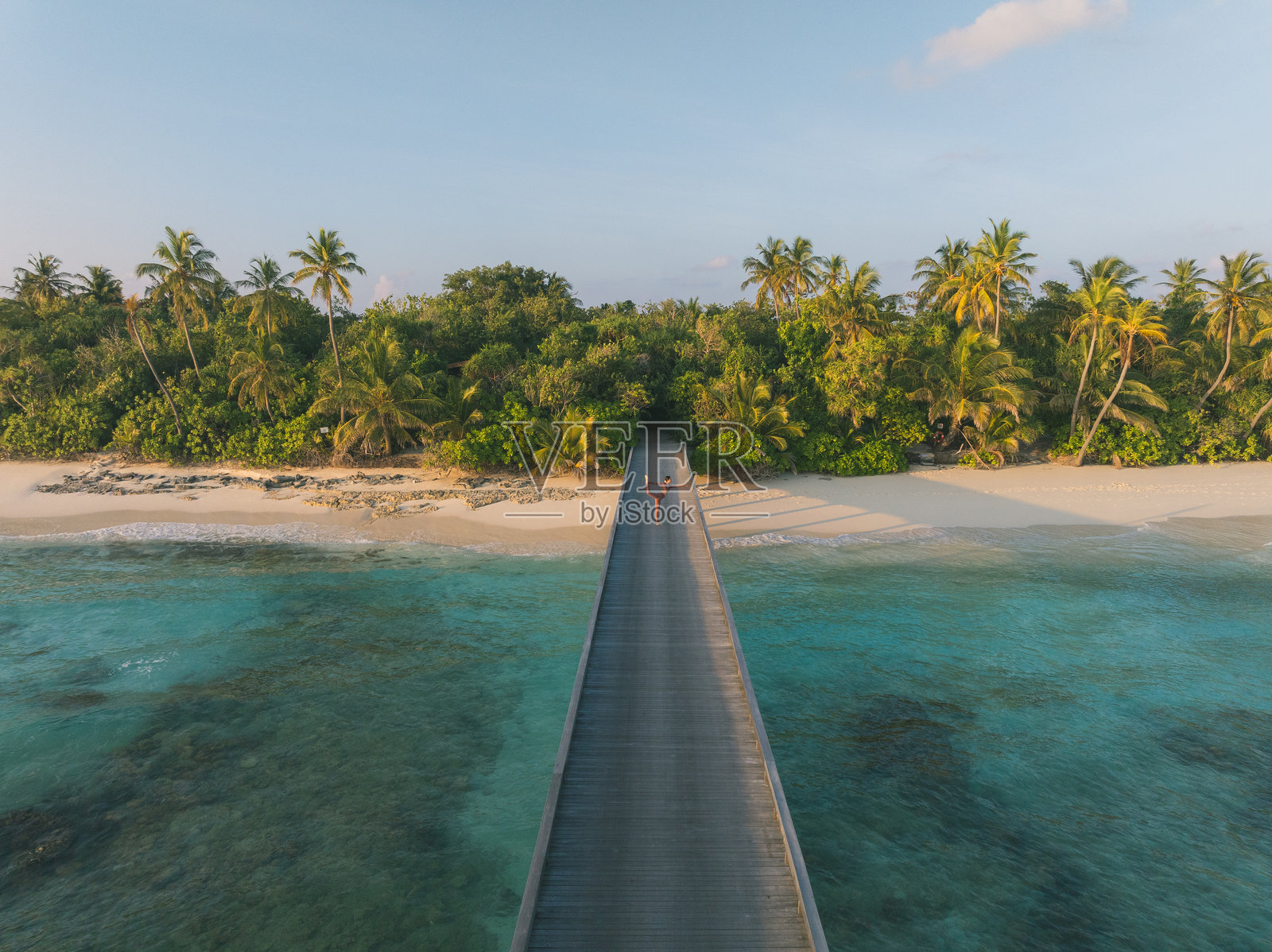 年轻女性在热带泻湖上的木栈道上做瑜伽动作的鸟瞰图照片摄影图片