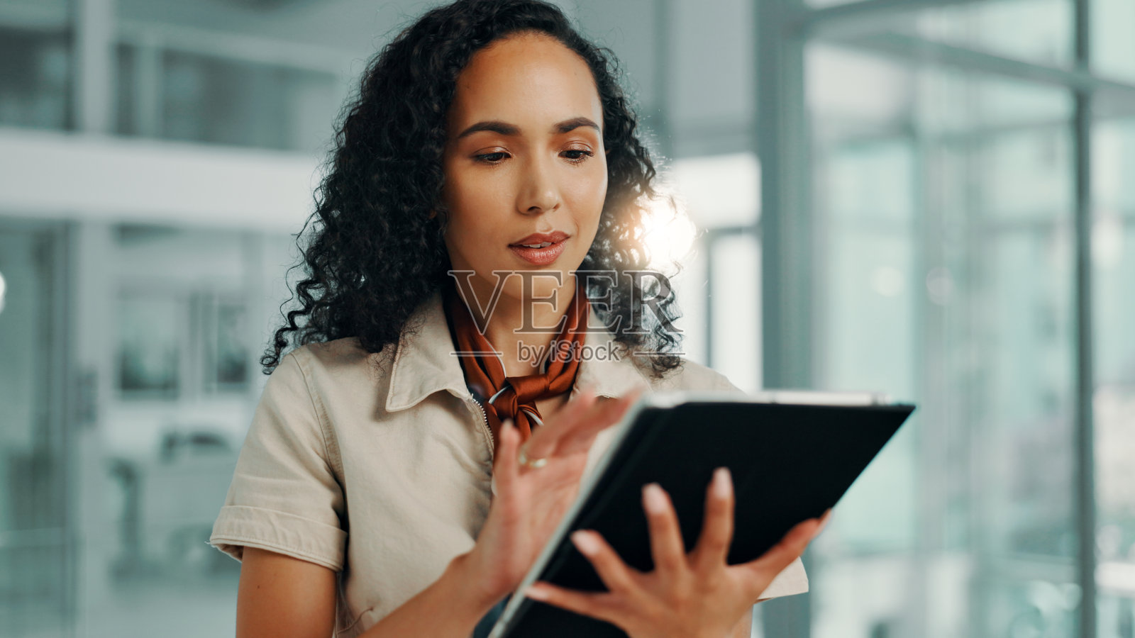 商务女性在办公室使用平板电脑进行时尚杂志、目录或应用的编辑工作。科技、互联网和在线工作者为创意初创公司设计趋势、安排日程或阅读电子邮件。照片摄影图片