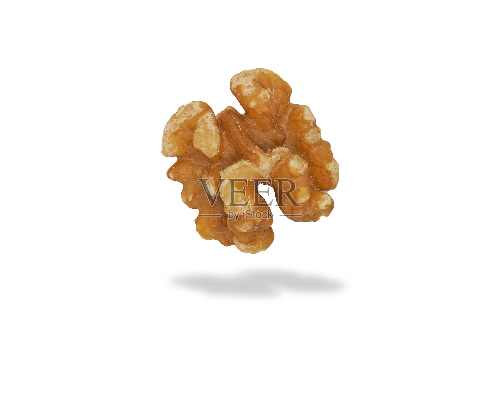 半空中的核桃半个,轻柔的阴影映衬在浅色背景上,展示其独特的纹理和形状。照片摄影图片