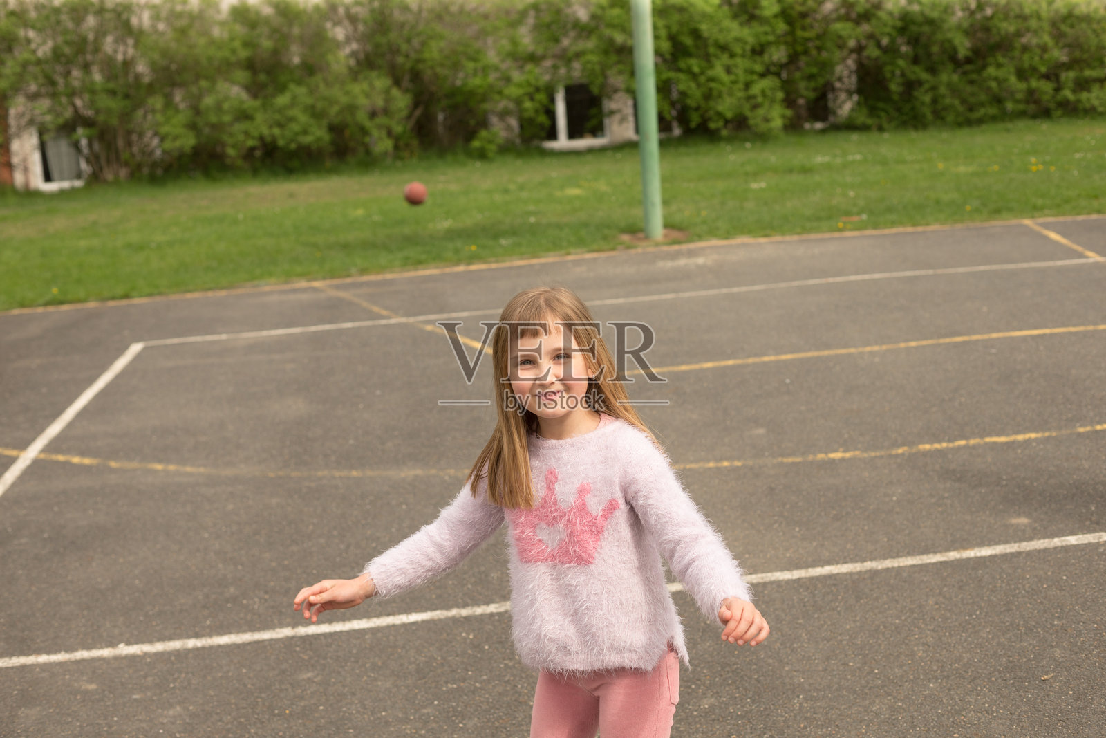 春天的篮球场上,一个年轻女孩正在进行有趣的活动照片摄影图片