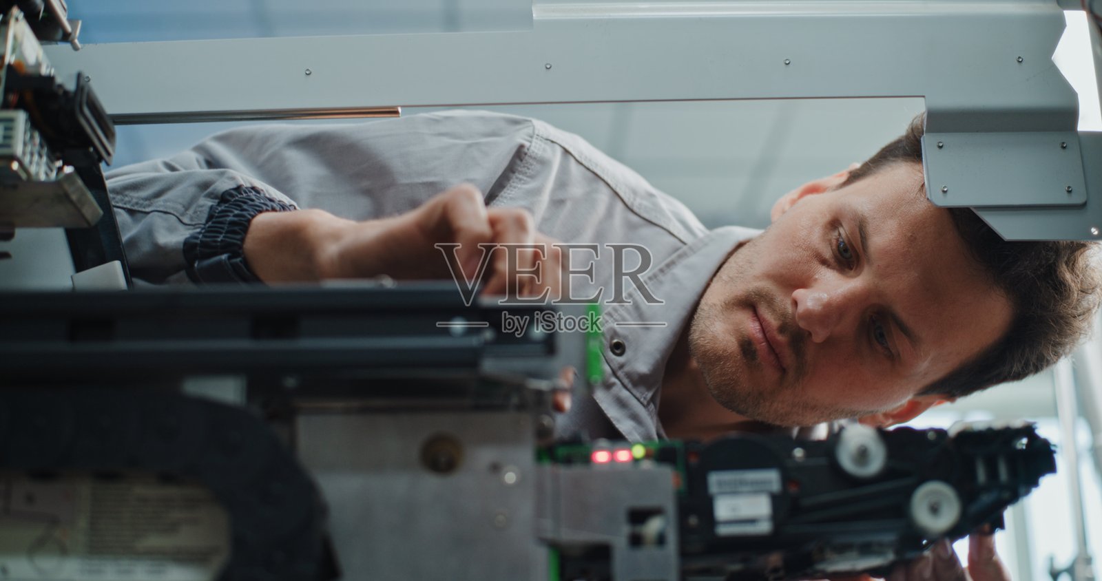 穿着制服的ATM技术人员正在对现金提款机进行维护照片摄影图片