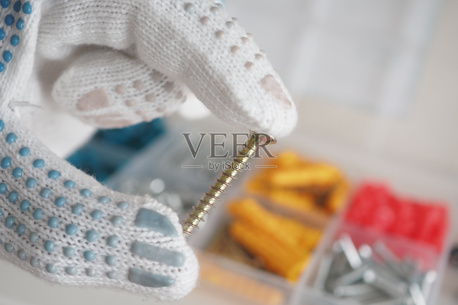 手握螺丝,旁边有整齐的工具和配件照片摄影图片