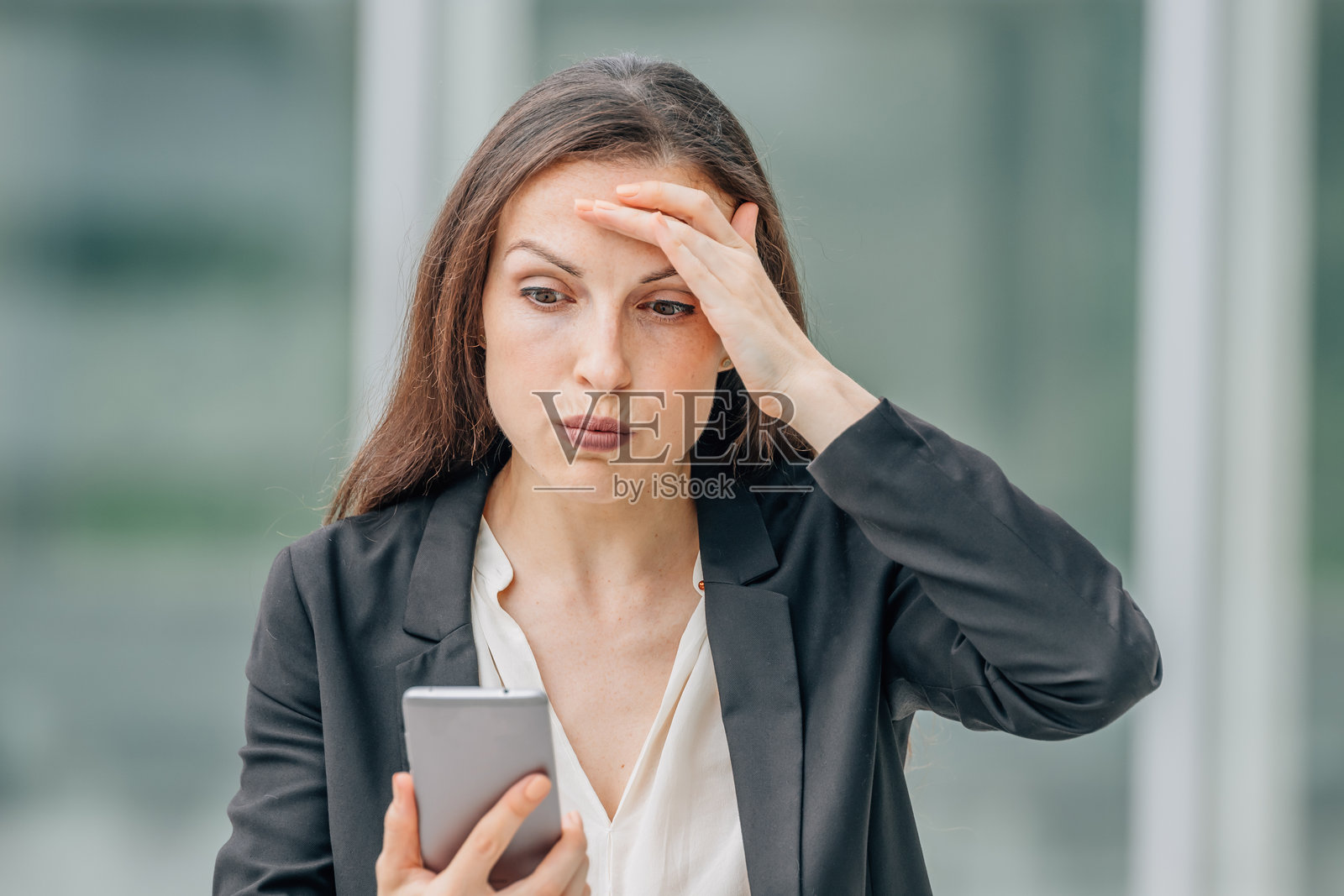 手持手机并带有表情的女商人照片摄影图片