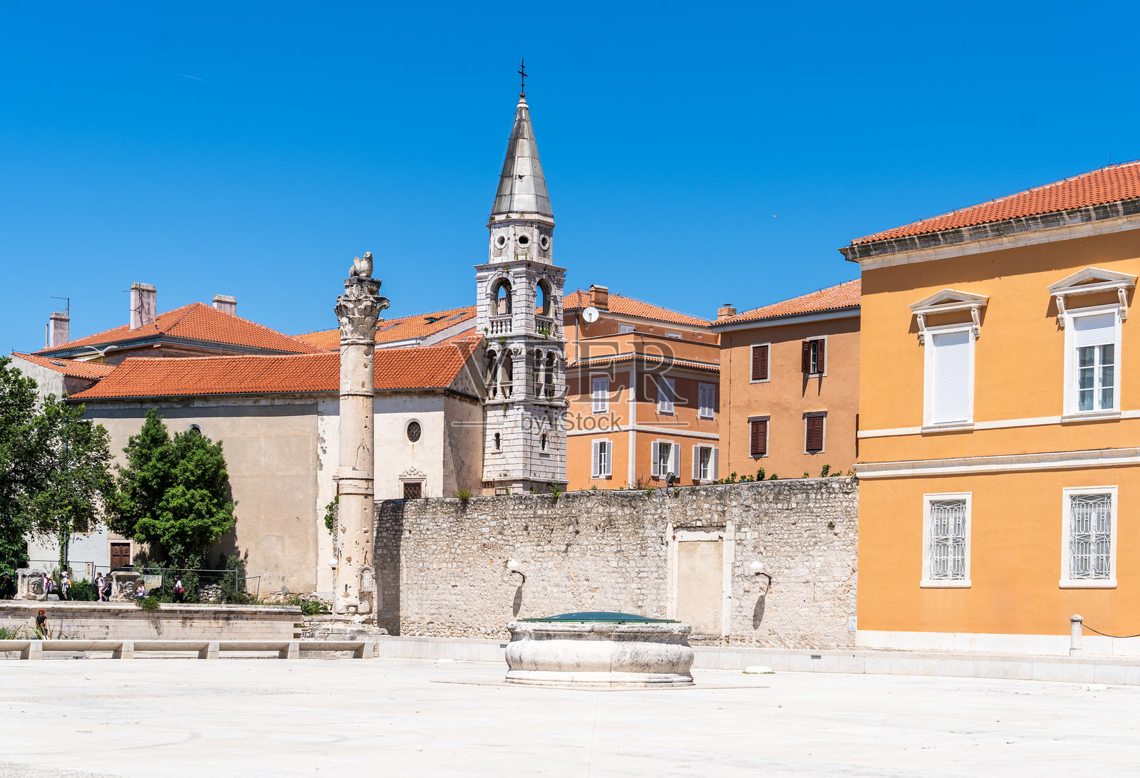 克罗地亚扎达尔的罗马广场考古遗址,背景是扎达尔大教堂钟楼和橙色建筑。照片摄影图片