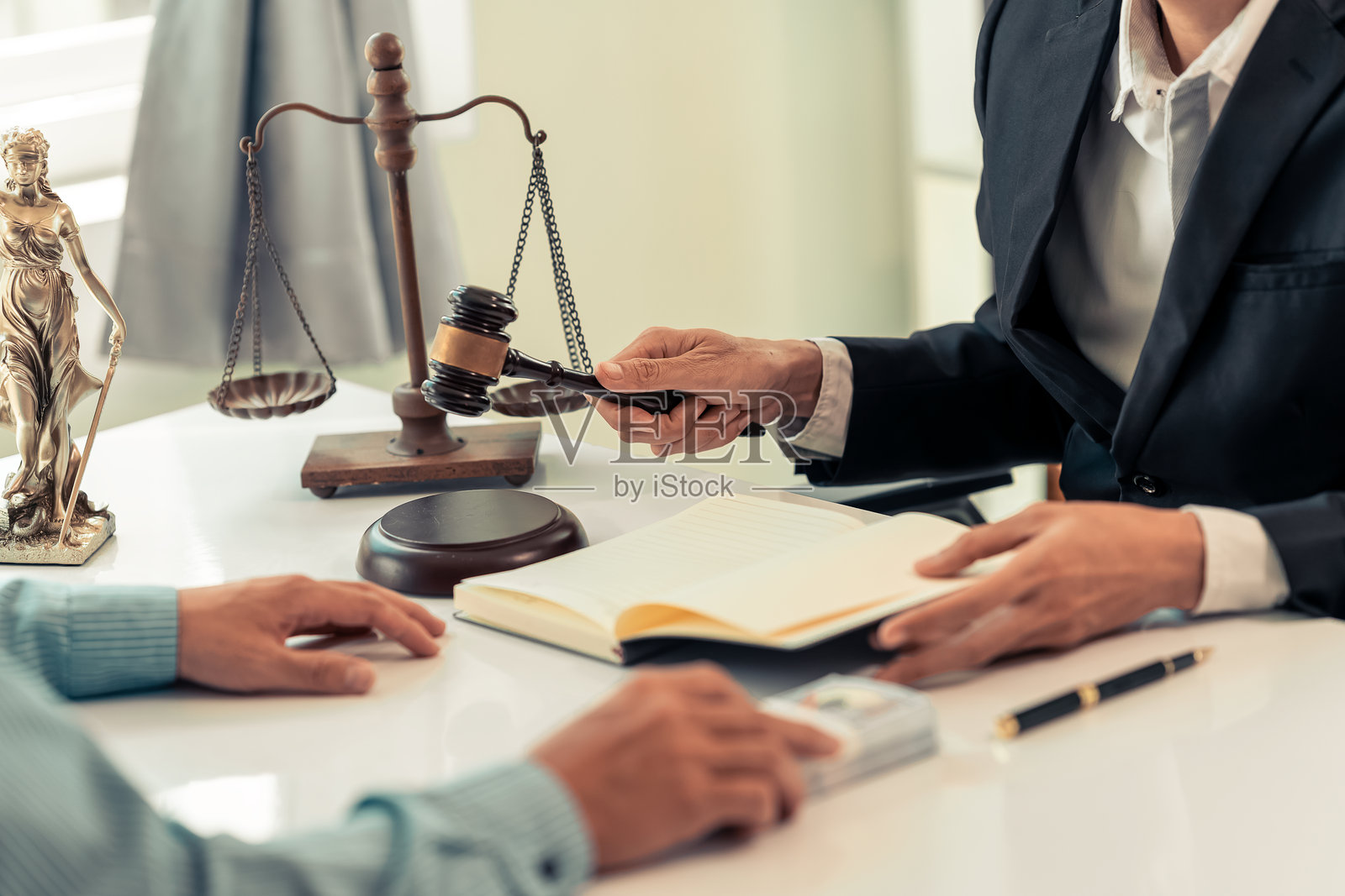 咨询与公正。律师与商人在进行咨询和谈判。法槌特写。男性律师或法官在现代办公室的桌子上阅读案件文件。照片摄影图片