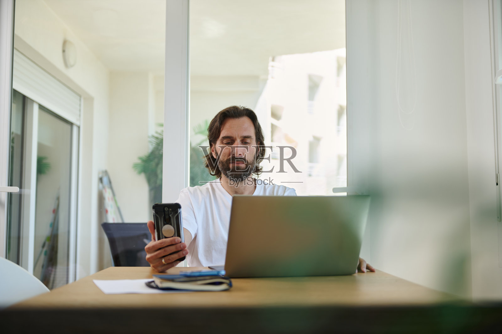 留着胡子的男人在家办公室用笔记本电脑进行远程工作照片摄影图片