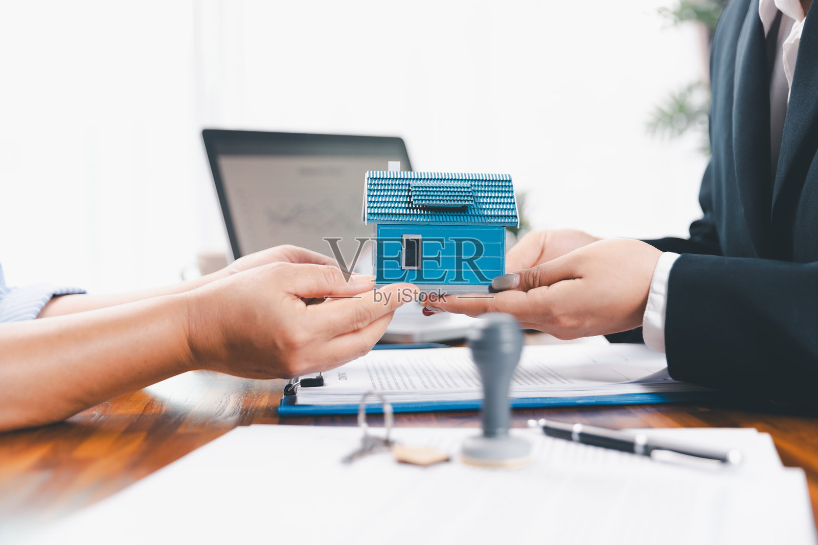 银行批准购房贷款的概念。房地产经纪人与客户讨论购房协议的条款,要求客户签署文件以使合同合法。批准的抵押贷款申请表。照片摄影图片