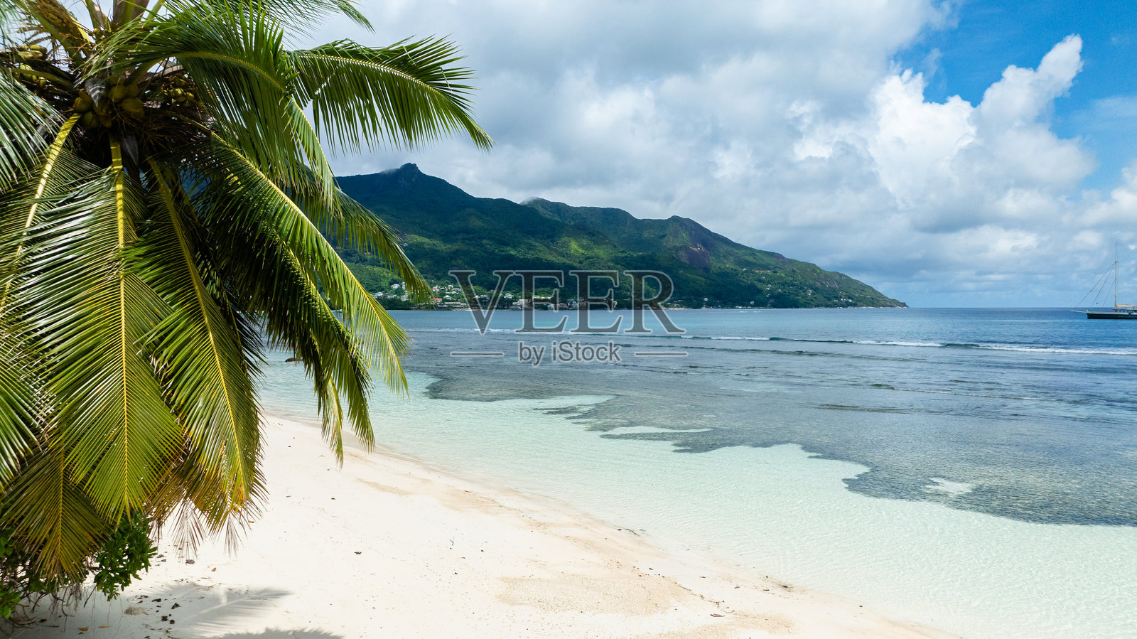 沙滩与碧蓝的海水和绿色的山丘。塞舌尔,马埃。照片摄影图片