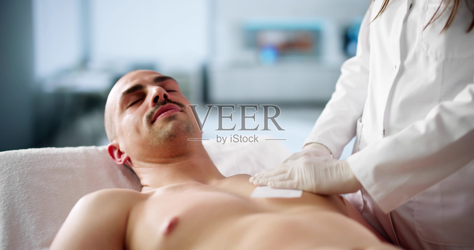 皮肤科医生在脱毛时痛苦地去除胸毛照片摄影图片