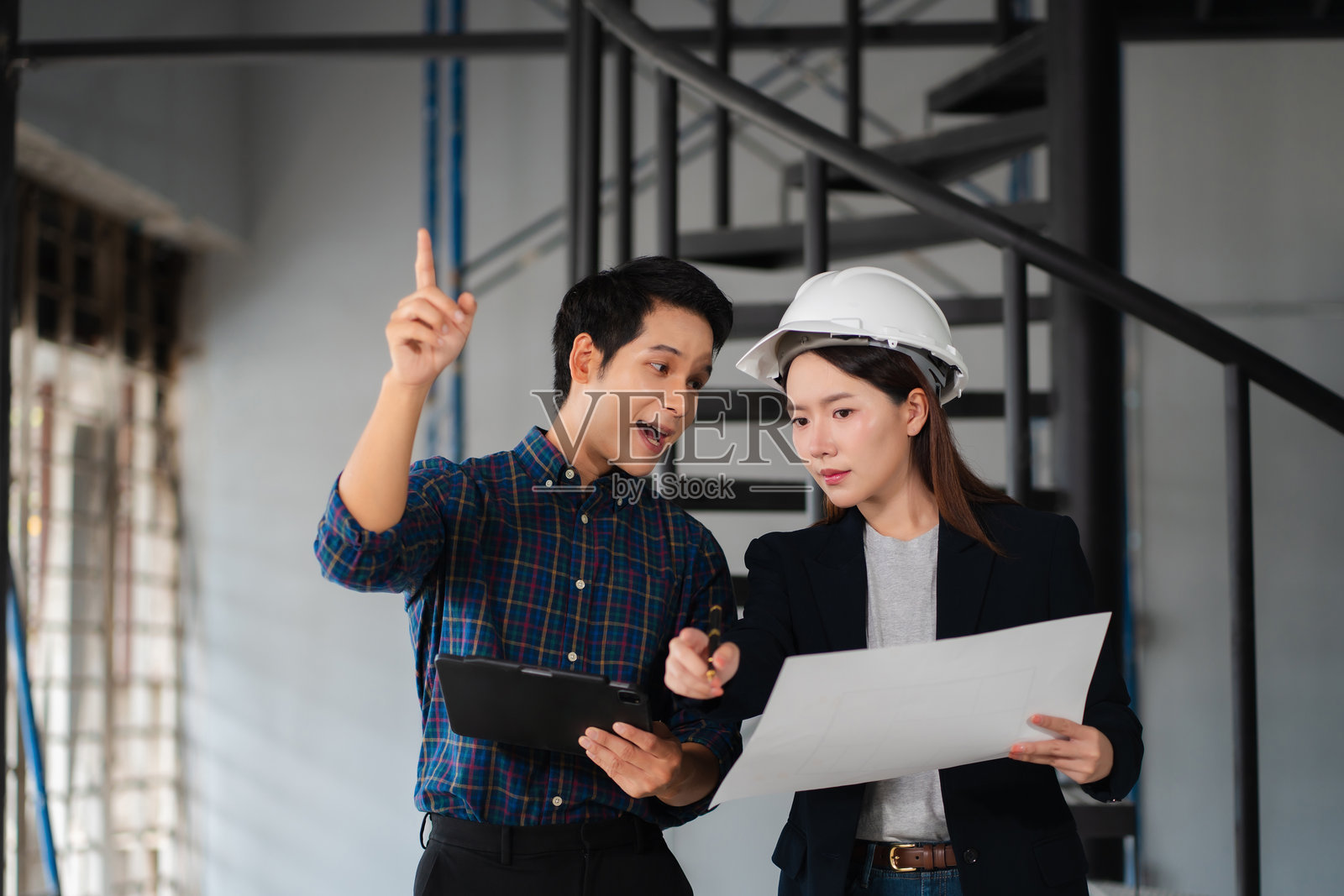 建筑工地上,施工工程师与建筑师进行讨论。照片摄影图片