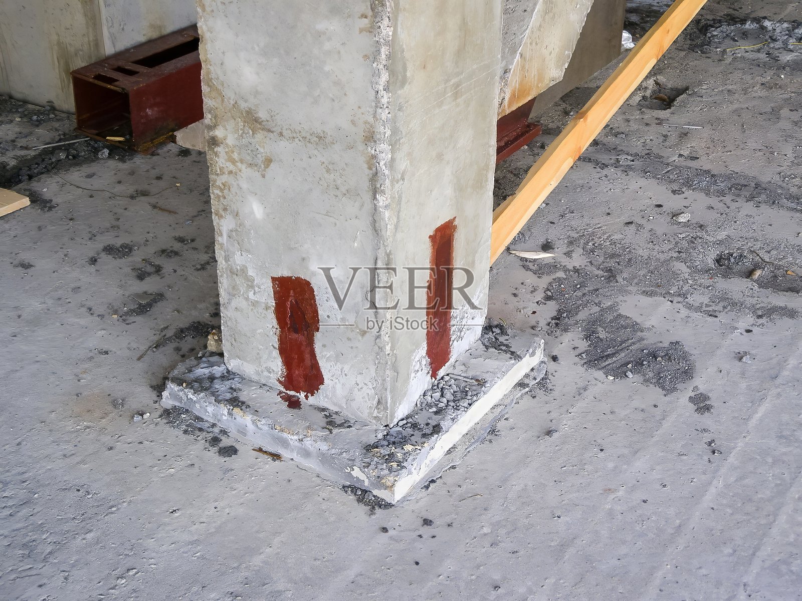 一根坚固的混凝土柱子矗立在工业建筑环境中,底部稳固扎根。照片摄影图片