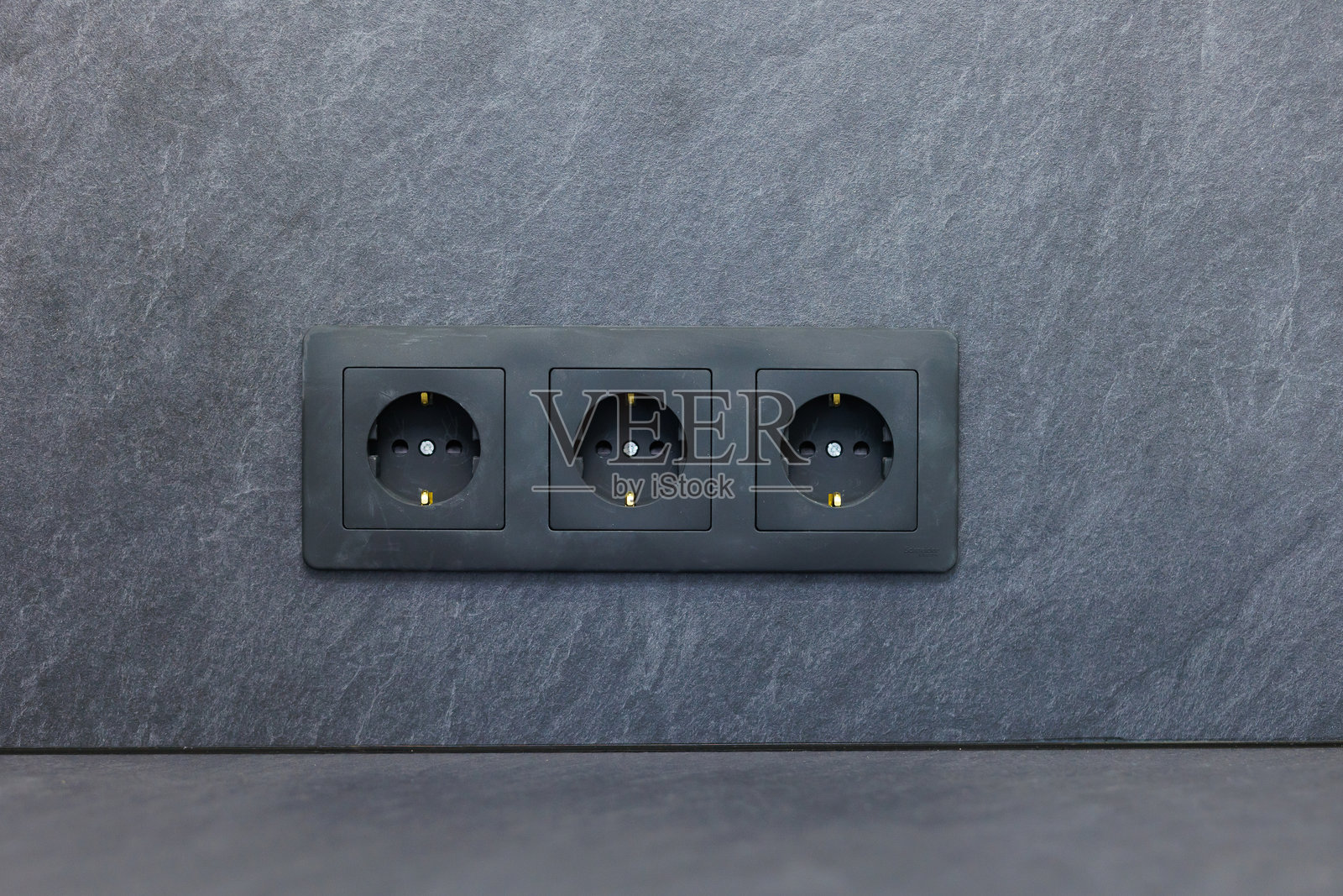 现代厨房中安装的三个电源插座,配有光滑的石材台面照片摄影图片