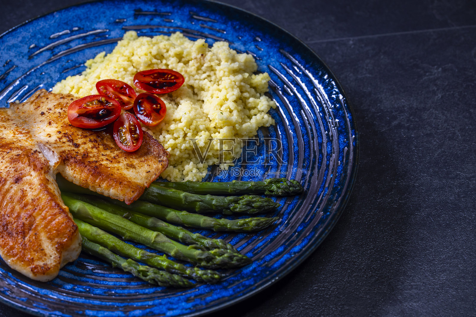 绿芦笋配鱼片和库斯库斯照片摄影图片