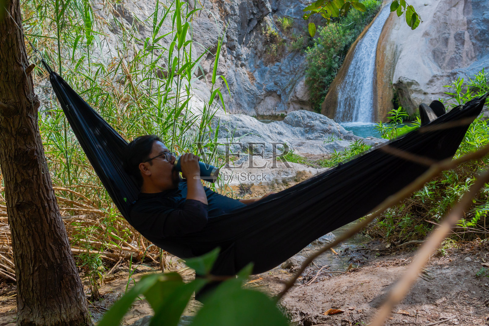 游客在墨西哥普埃布拉的瀑布旁放松地躺在吊床上照片摄影图片