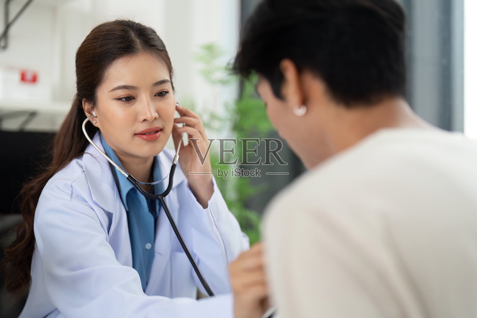 健康与保健。医生使用听诊器评估患者的健康状况。照片摄影图片