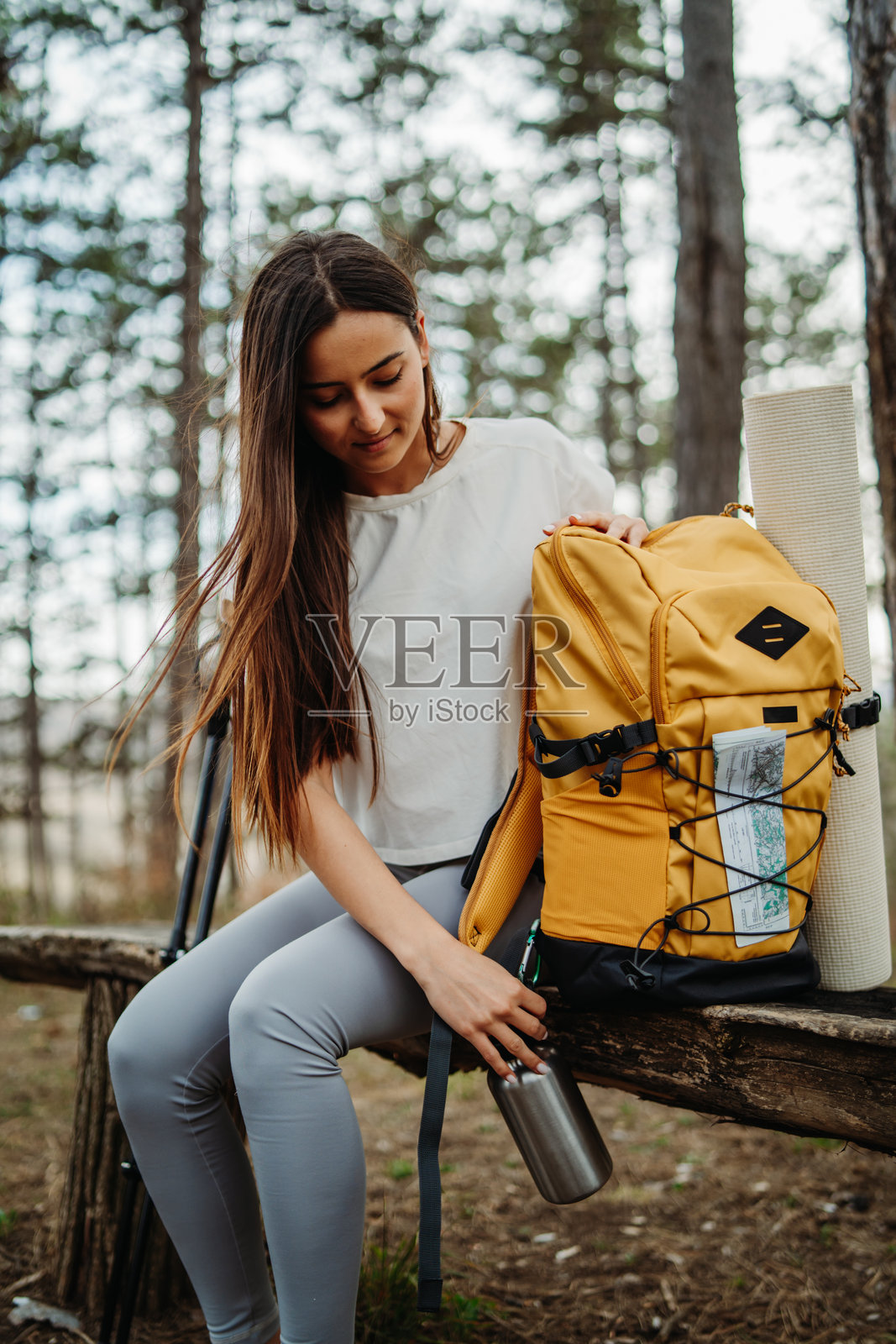年轻女性在风景如画的森林中徒步旅行后休息。照片摄影图片