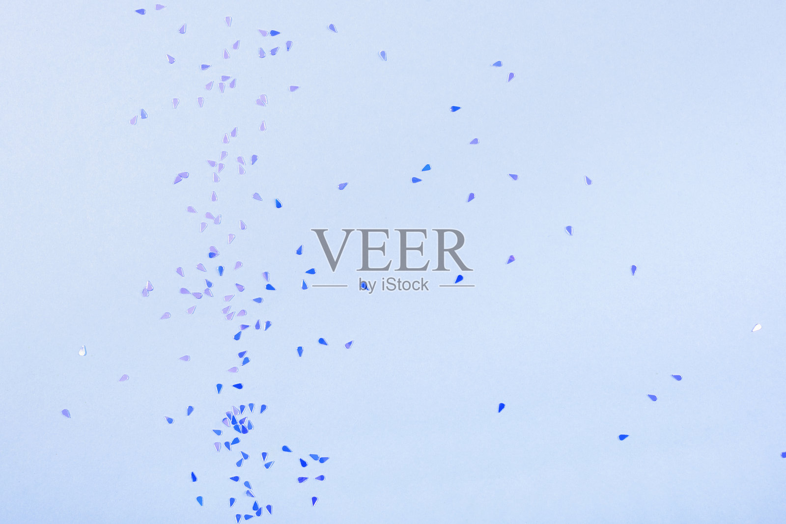 蓝色闪亮的彩纸屑在蓝色背景上,俯视图照片摄影图片