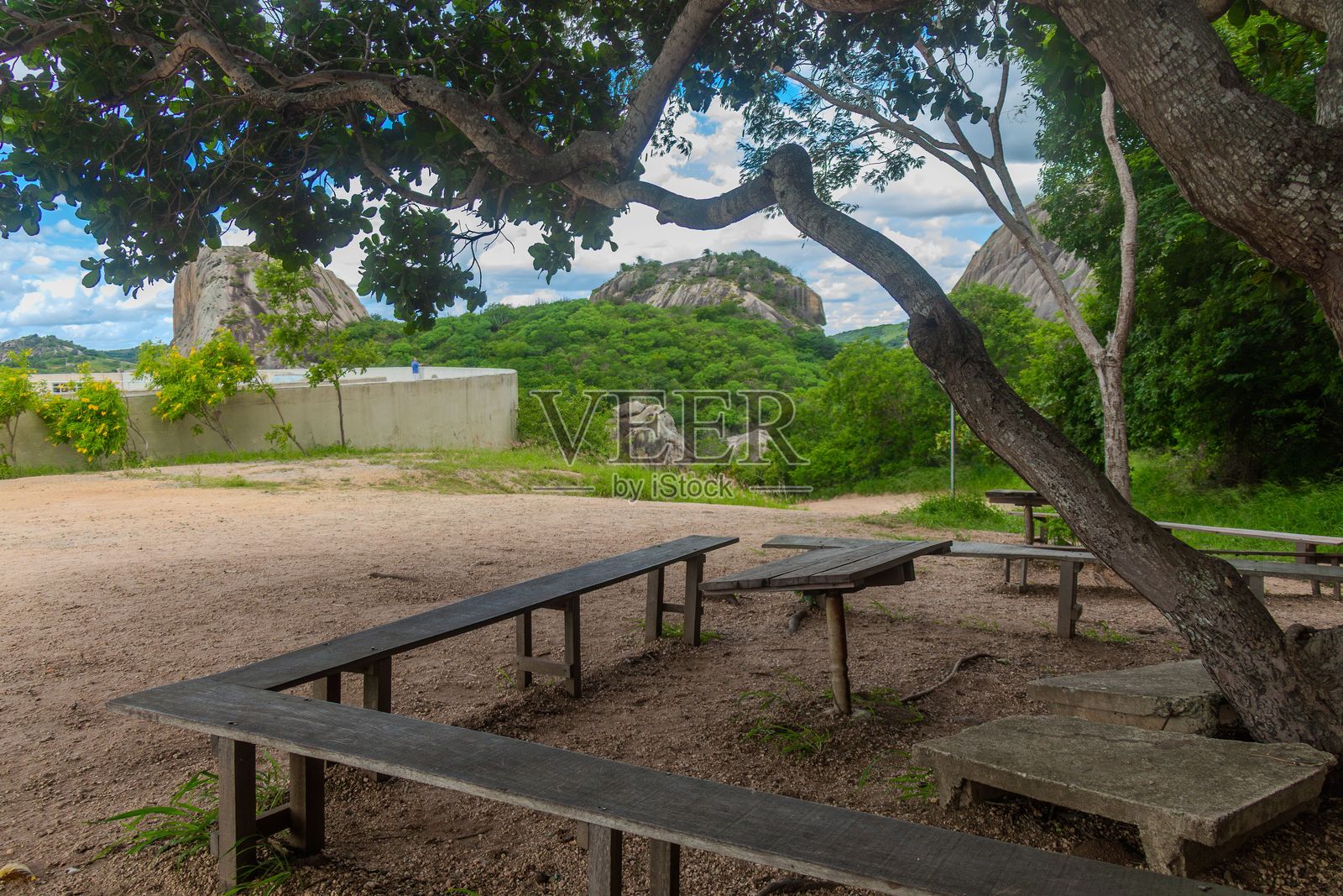 风景如画的岩石景观,配有树木和长椅。照片摄影图片