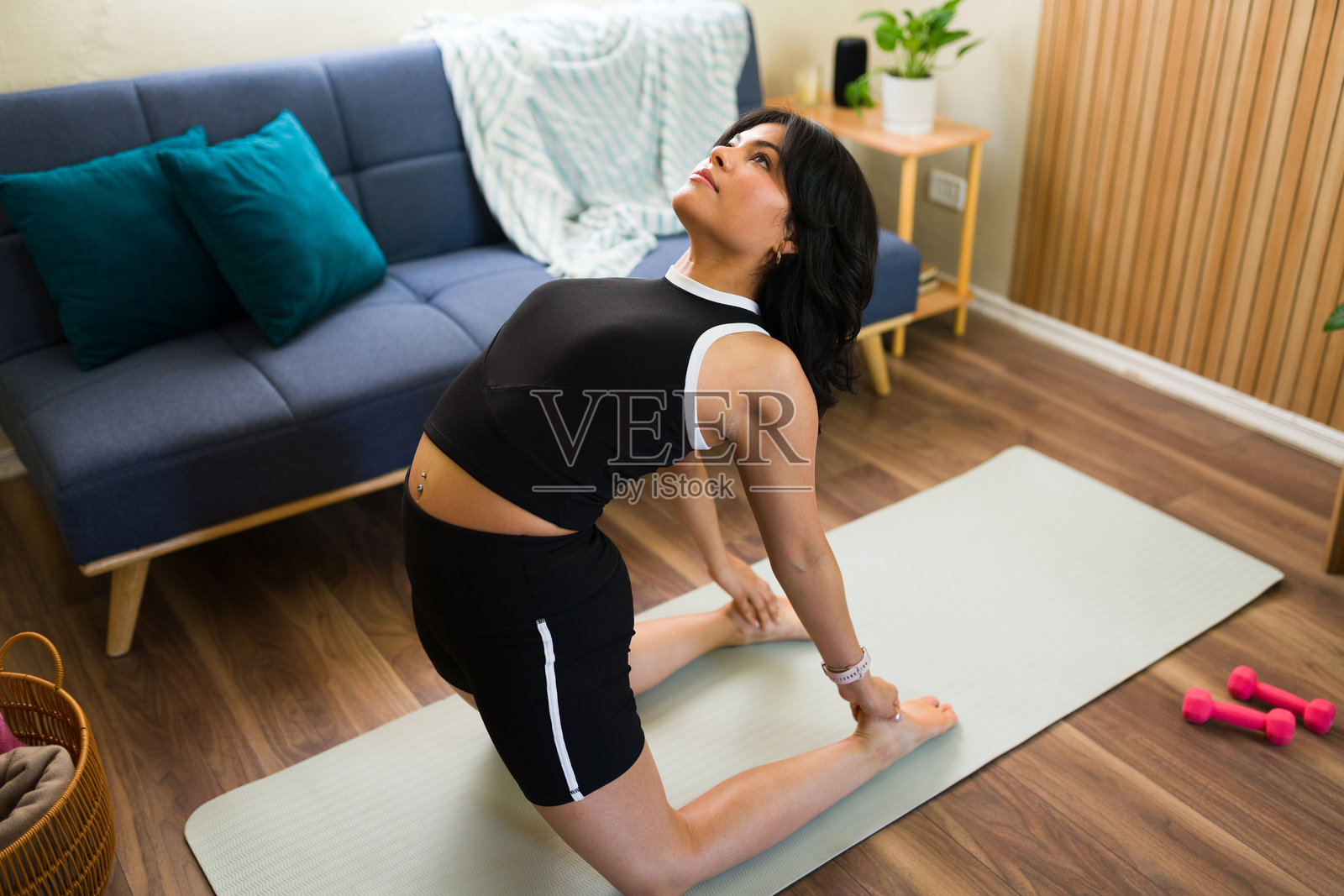 年轻女性在家中做骆驼式瑜伽姿势照片摄影图片