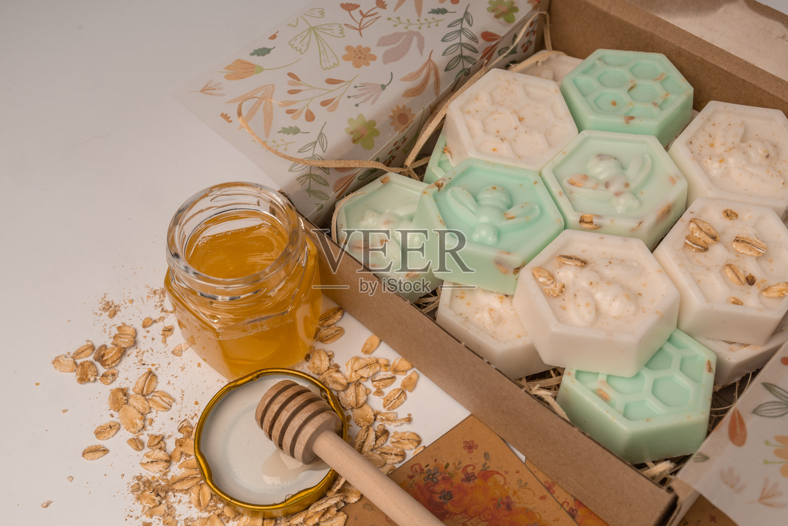 手工制作的小蜂窝燕麦和蜂蜜香皂条,装在盒子里。美观的香皂在白色背景上,留有空白空间。照片摄影图片