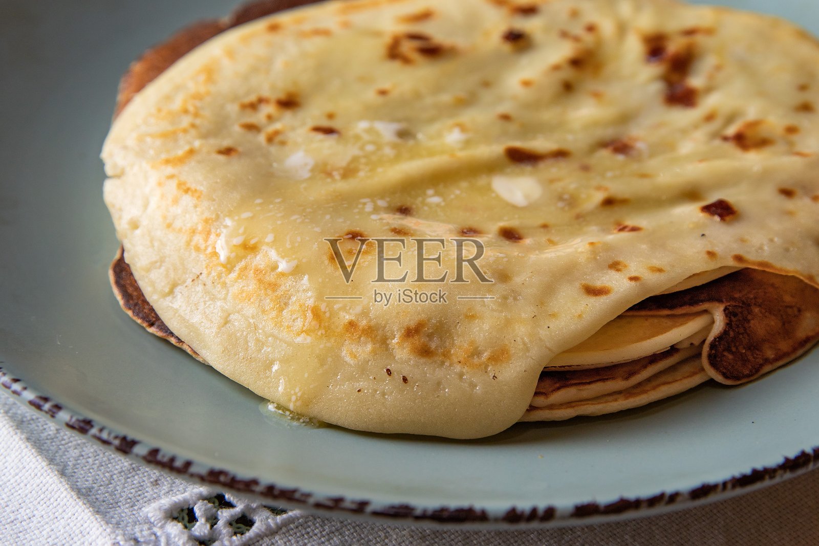 传统自制煎饼配黄油,放在乡村风格的盘子上,复古美食风格照片摄影图片