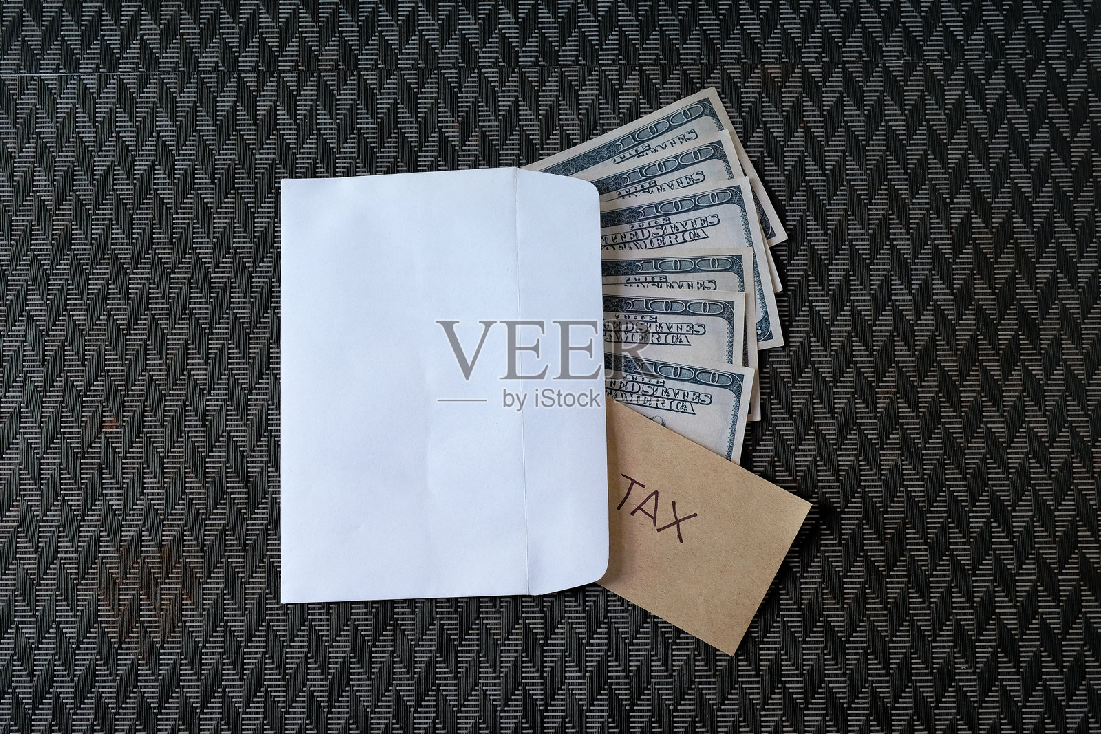 装有写有“税”的纸条的现金美元。照片摄影图片