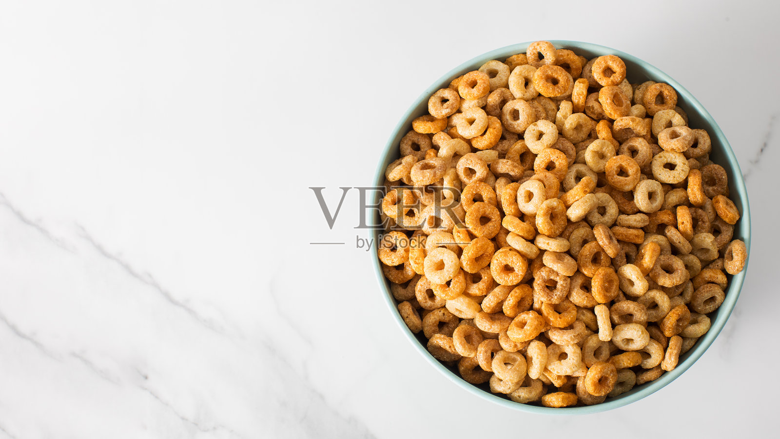 一碗圆形脆麦片配牛奶。健康早餐。留白空间。照片摄影图片