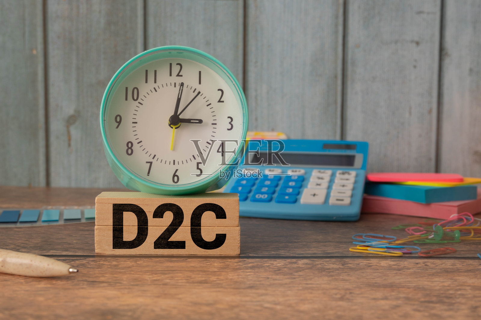 桌子上放着写有D2C概念的木块,旁边有一朵花照片摄影图片